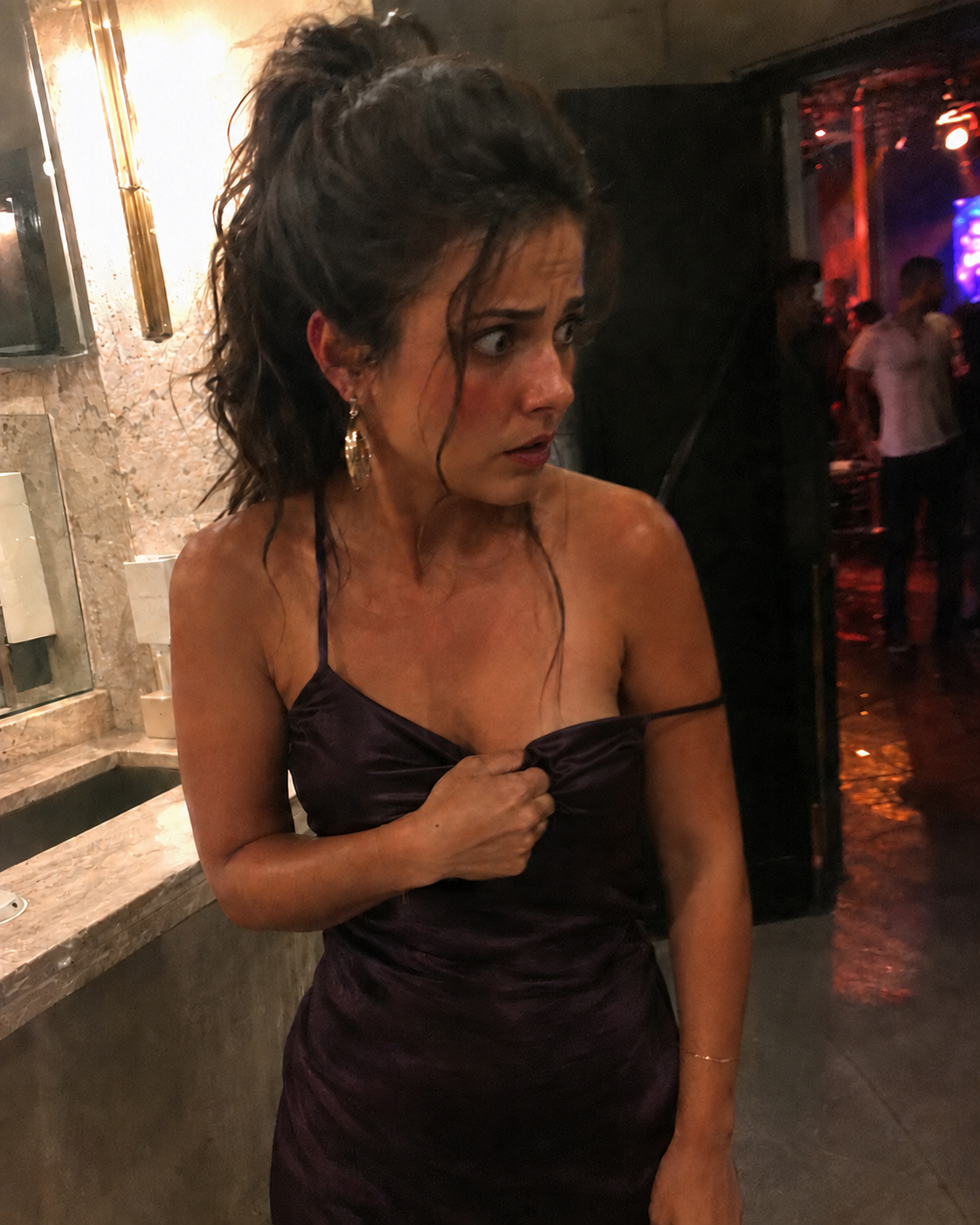 תמונת המחשה של אישה באירוע שמחזיקה את מחשוף השמלה ונראית מבוהלת